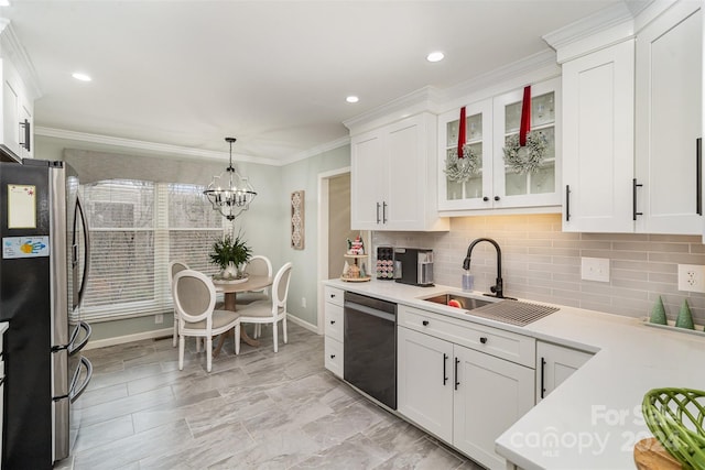 kitchen with sink, white cabinets, stainless steel appliances, and decorative light fixtures