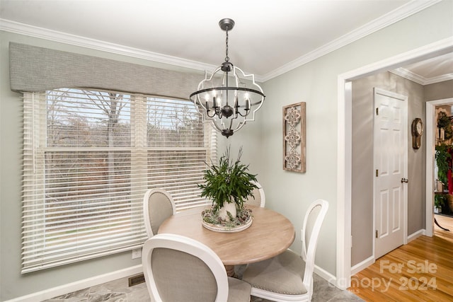 dining space with hardwood / wood-style flooring, crown molding, and a notable chandelier