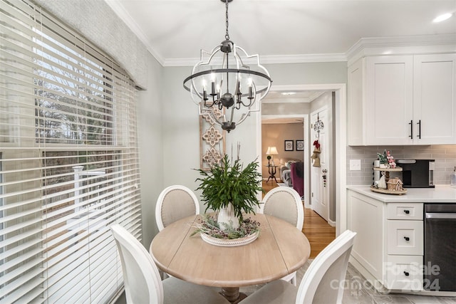 dining room with light hardwood / wood-style floors, crown molding, and a notable chandelier