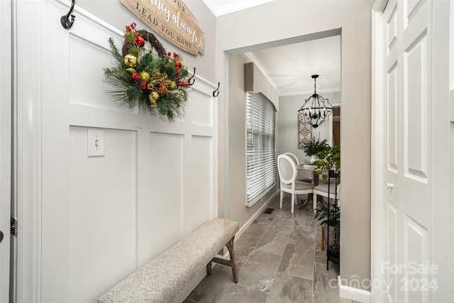 hall featuring crown molding and a notable chandelier