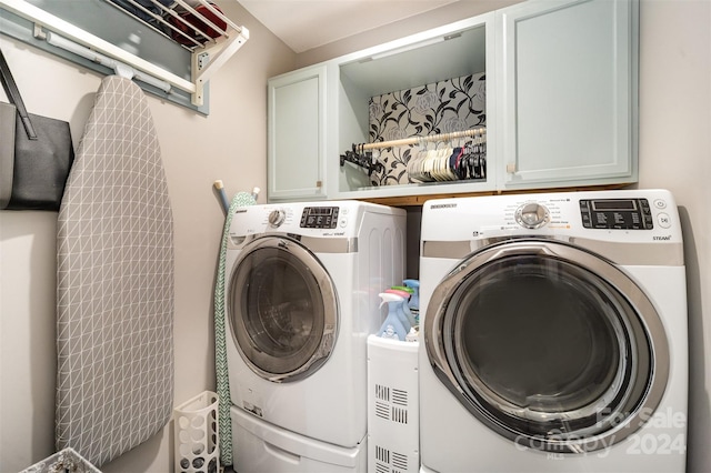 laundry room featuring separate washer and dryer and cabinets