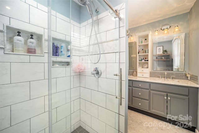 bathroom featuring vanity, a shower with shower door, and backsplash