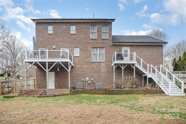 rear view of house featuring a lawn, a wooden deck, and central air condition unit