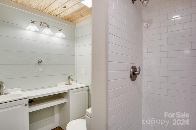 bathroom with vanity, toilet, wooden ceiling, and tiled shower