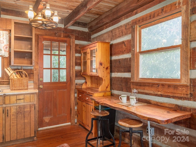 dining area featuring breakfast area, hardwood / wood-style flooring, beamed ceiling, a notable chandelier, and wood ceiling