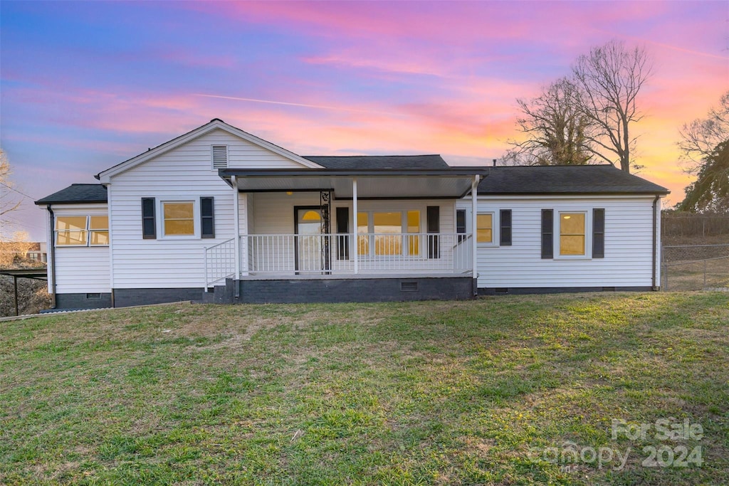 ranch-style house featuring a porch and a yard