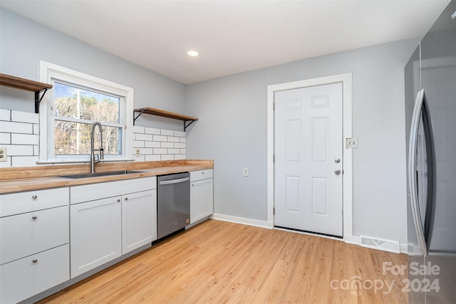 kitchen featuring white cabinetry, sink, appliances with stainless steel finishes, and wood counters