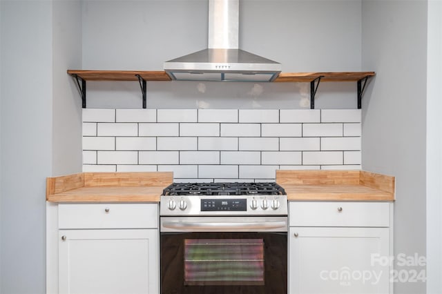 kitchen featuring white cabinetry, stainless steel range with gas cooktop, exhaust hood, and tasteful backsplash