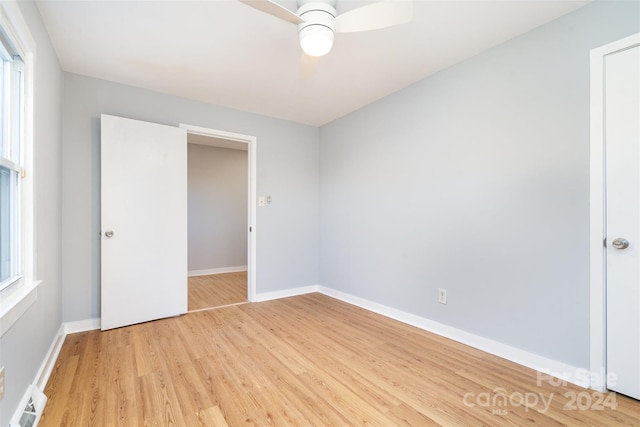 unfurnished bedroom with multiple windows, a closet, light hardwood / wood-style floors, and ceiling fan