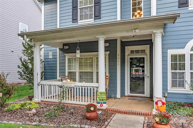 view of exterior entry featuring covered porch