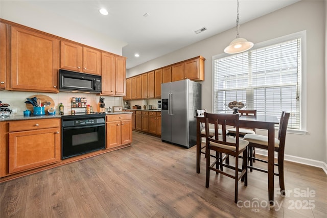 kitchen featuring black appliances, decorative light fixtures, decorative backsplash, and hardwood / wood-style flooring