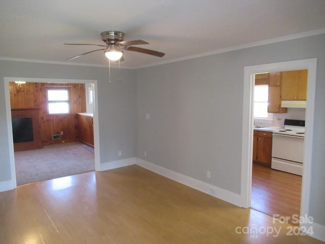 unfurnished living room with sink, light hardwood / wood-style flooring, ceiling fan, ornamental molding, and baseboard heating