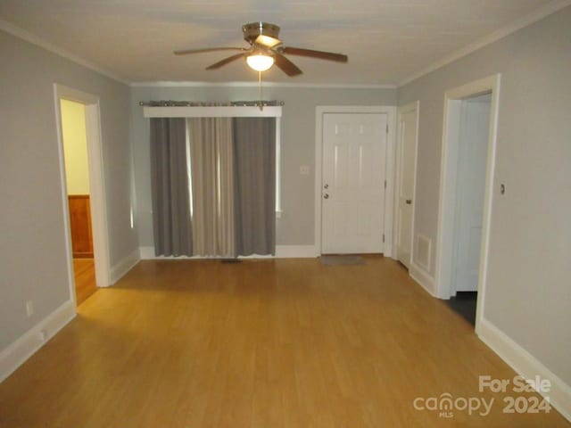 unfurnished room featuring ceiling fan, light hardwood / wood-style floors, and crown molding