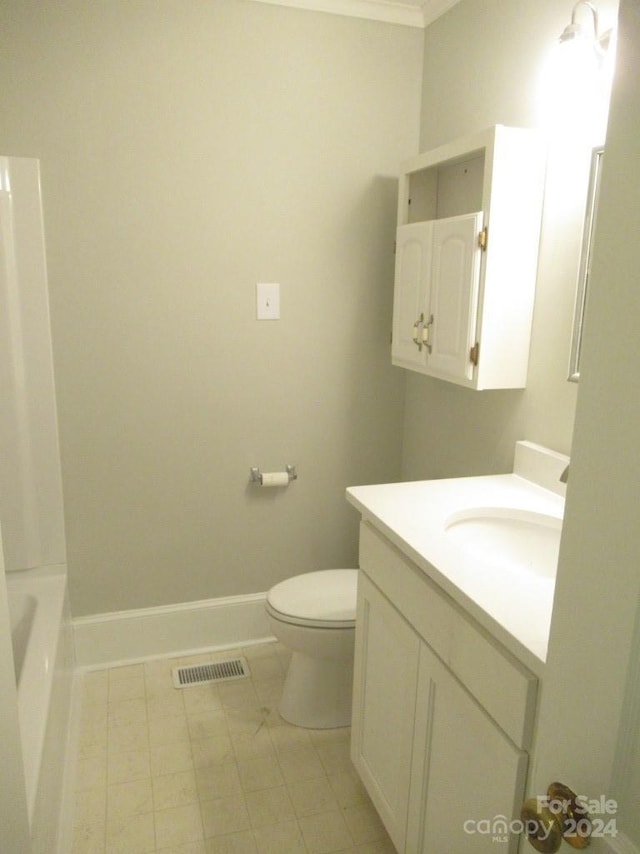 bathroom featuring ornamental molding, vanity, toilet, and a tub