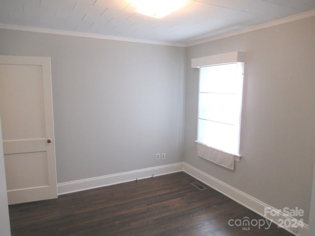 empty room featuring dark hardwood / wood-style floors and ornamental molding