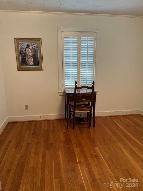 dining area featuring wood-type flooring and crown molding