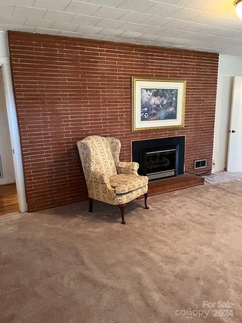 sitting room with a fireplace and carpet