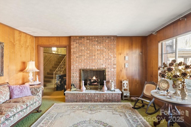 living room featuring wood walls, carpet, and a brick fireplace