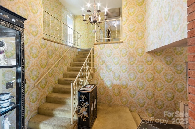 stairs with a notable chandelier