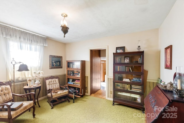 living area featuring carpet floors and wooden walls