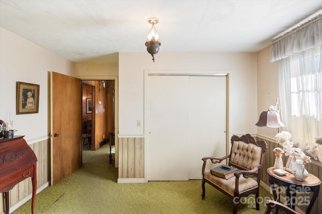 sitting room with carpet and wooden walls