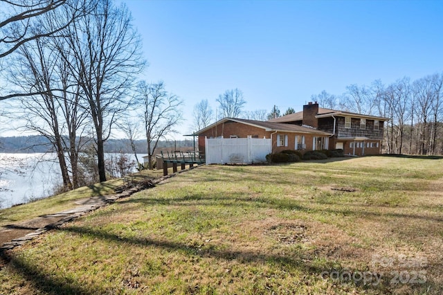 view of side of home featuring a lawn and a water view