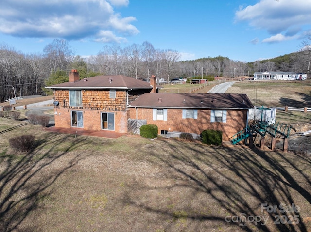 rear view of property with a lawn