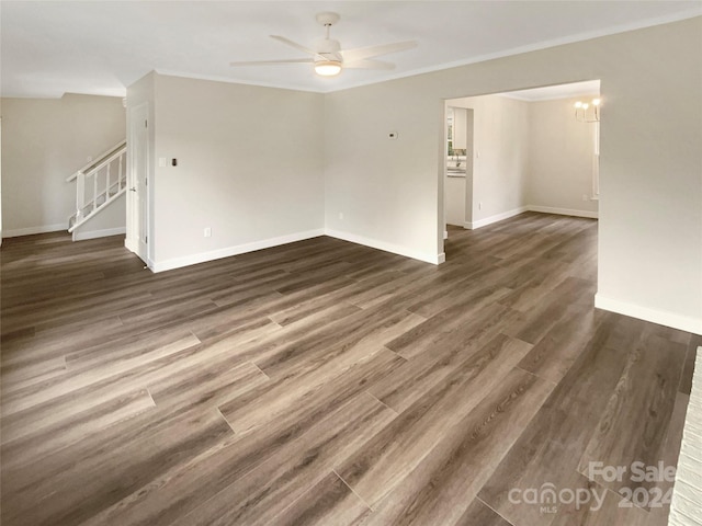 unfurnished room with crown molding, dark wood-type flooring, and ceiling fan with notable chandelier