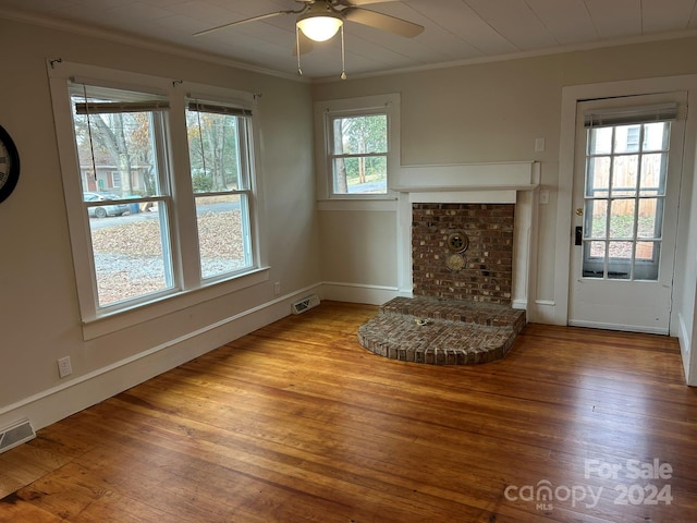 unfurnished living room with ceiling fan, a fireplace, light wood-type flooring, and ornamental molding