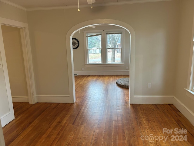 empty room featuring hardwood / wood-style flooring and ornamental molding