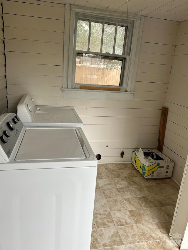 laundry area featuring washer and dryer and wood walls