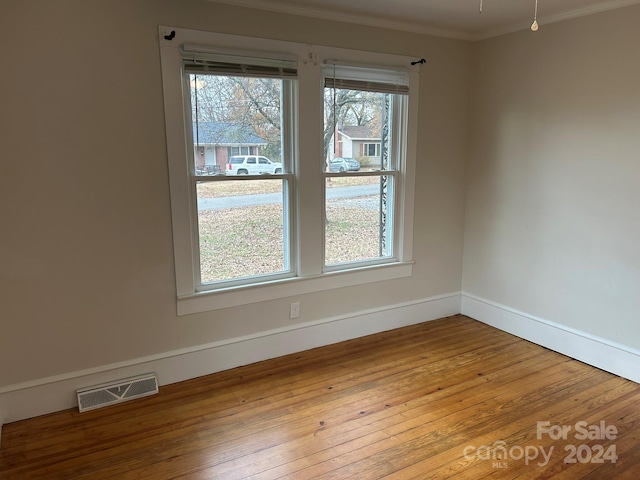 unfurnished room with light hardwood / wood-style flooring and ornamental molding