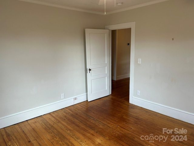 unfurnished room featuring dark hardwood / wood-style floors and ornamental molding