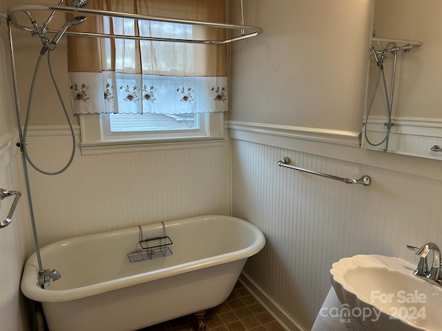 bathroom with a bath, tile patterned floors, and sink