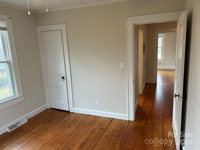 interior space featuring multiple windows, crown molding, and hardwood / wood-style floors