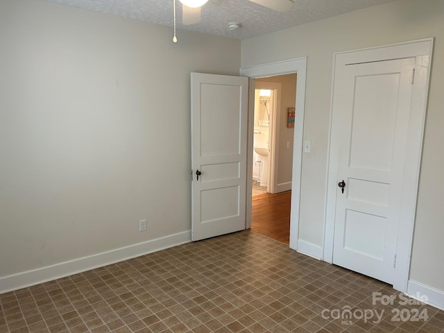 unfurnished bedroom featuring ceiling fan and a textured ceiling