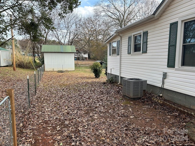 view of yard featuring central AC unit and a shed