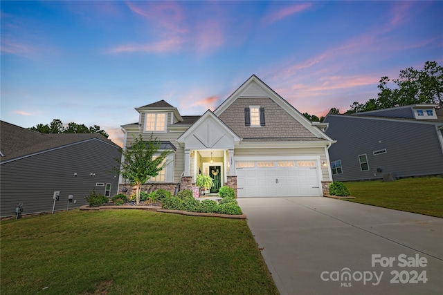 view of front of home with a yard and a garage