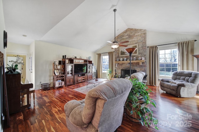 living room featuring a healthy amount of sunlight, ceiling fan, a fireplace, and dark wood-type flooring