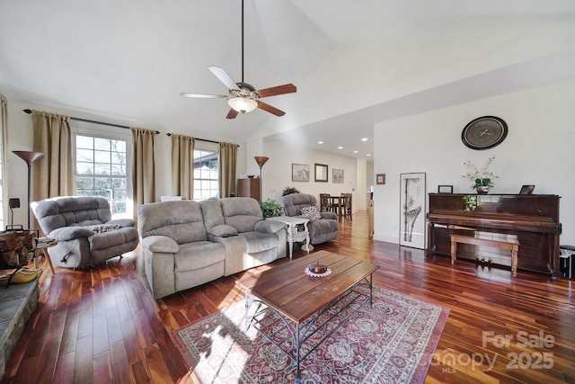 living room featuring ceiling fan, dark wood-type flooring, and vaulted ceiling