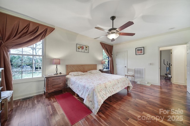 bedroom with ceiling fan, ornamental molding, dark wood-type flooring, and a closet