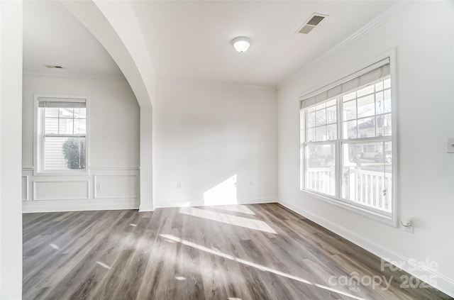 empty room featuring hardwood / wood-style floors, plenty of natural light, and crown molding