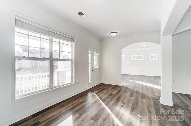 entryway with dark hardwood / wood-style flooring, crown molding, and a wealth of natural light