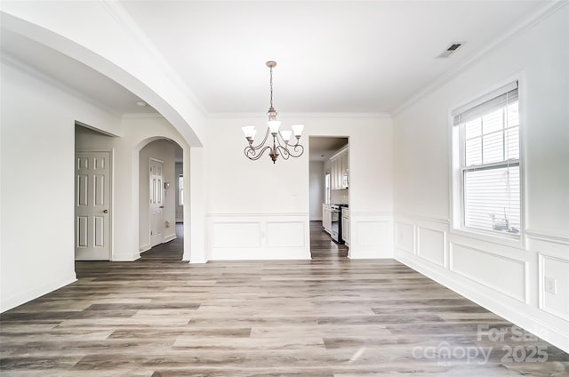 unfurnished dining area with a healthy amount of sunlight, an inviting chandelier, and ornamental molding