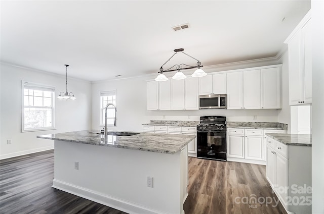 kitchen with sink, white cabinets, black gas stove, and an island with sink