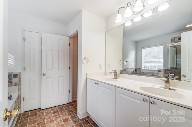 bathroom featuring vanity, a washtub, and a chandelier