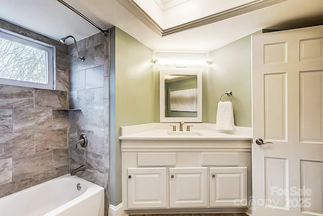 bathroom featuring vanity, crown molding, and tiled shower / bath combo