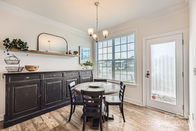 dining space featuring crown molding, a notable chandelier, and light wood-type flooring