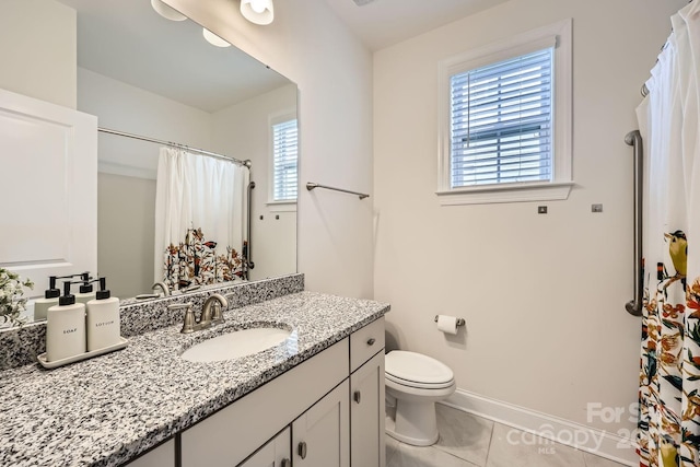 bathroom with toilet, vanity, and tile patterned flooring