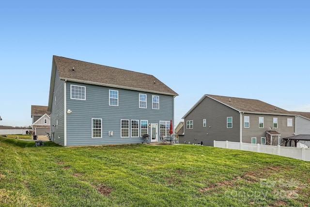 rear view of house featuring a yard